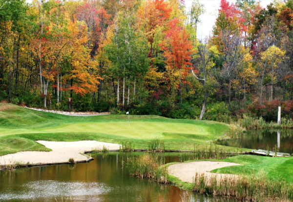 photo of a golf course green with water and sand trap