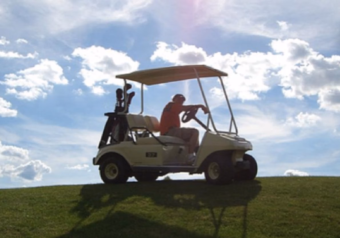 Golf league cart on a hill with blue sky