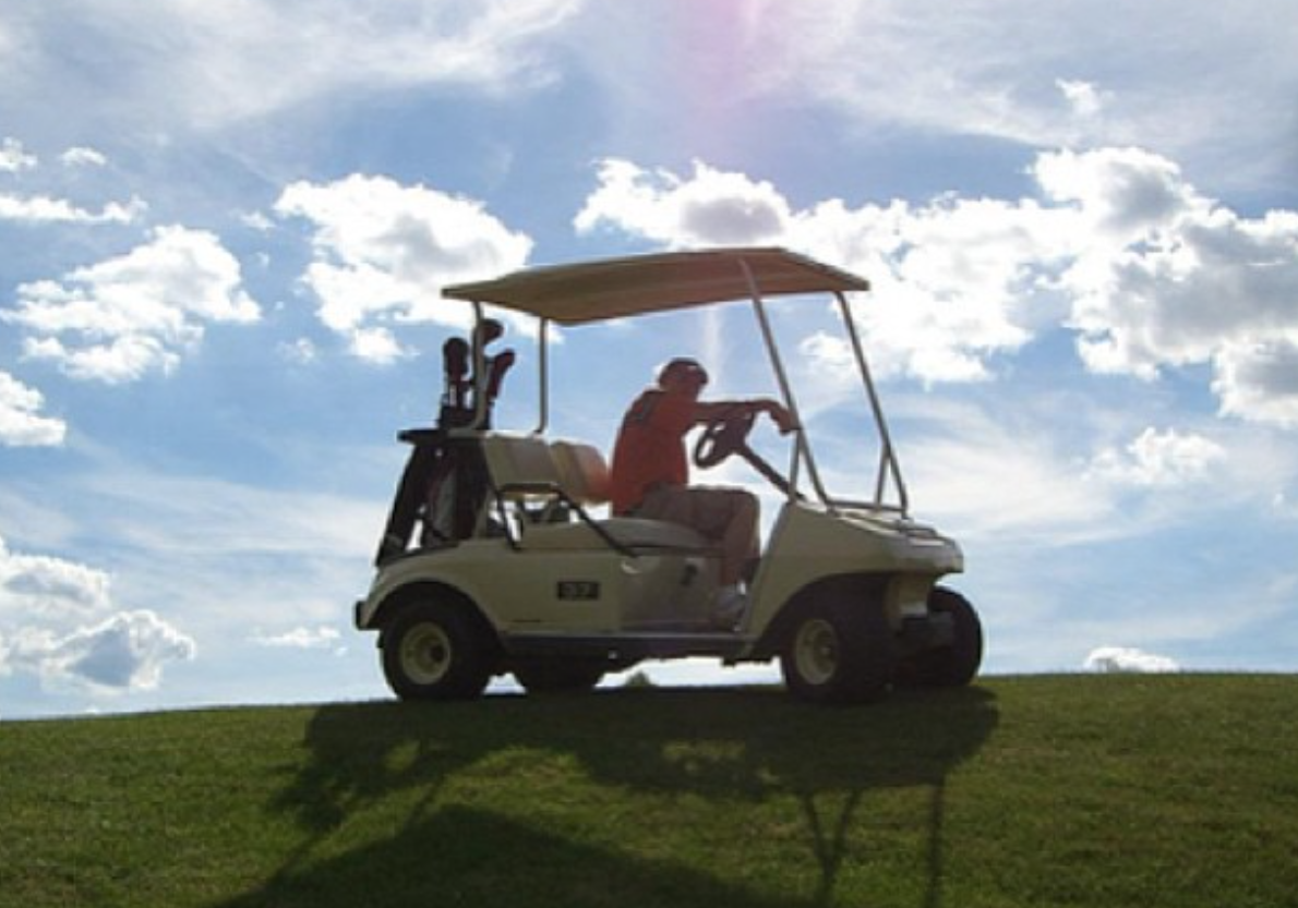 Golf league cart on a hill with blue sky