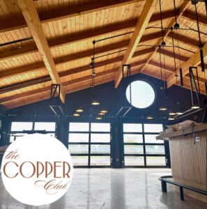 Restaurant with tall ceilings the copper club doors opening to golf course views